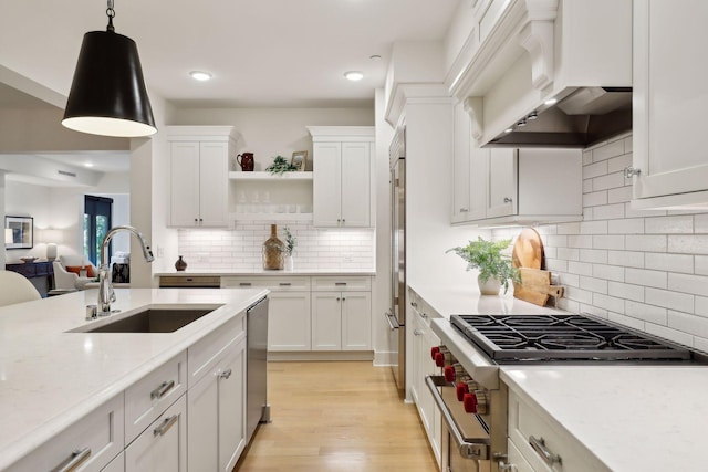 kitchen featuring light hardwood / wood-style floors, white cabinetry, sink, premium range hood, and stainless steel range