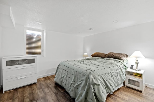 bedroom featuring baseboards and wood finished floors