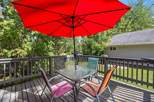 wooden terrace featuring outdoor dining area and a yard