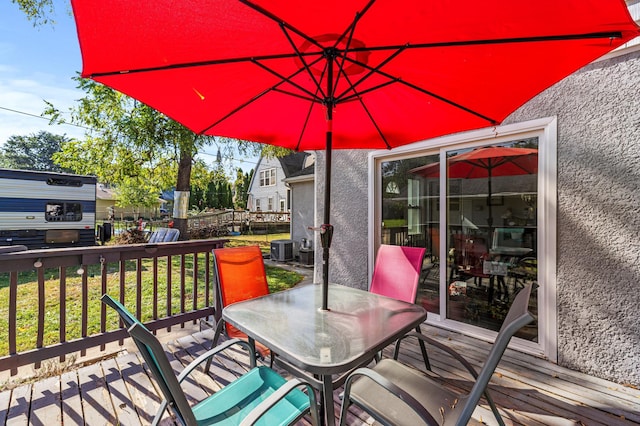 wooden deck featuring outdoor dining space and central air condition unit