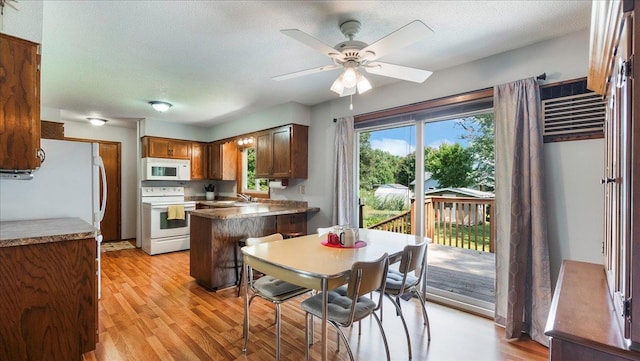 kitchen with white appliances, ceiling fan, light wood finished floors, and a textured ceiling