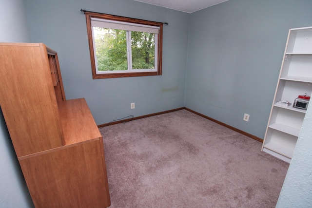 interior space featuring light colored carpet and baseboards