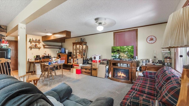 carpeted living area with a textured ceiling, ornamental molding, and a glass covered fireplace