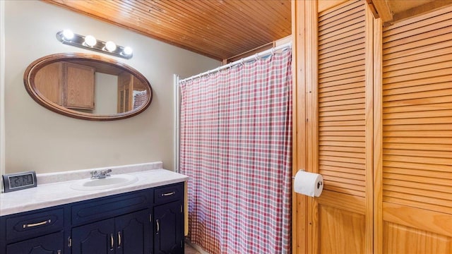 bathroom featuring a closet, wooden ceiling, and vanity