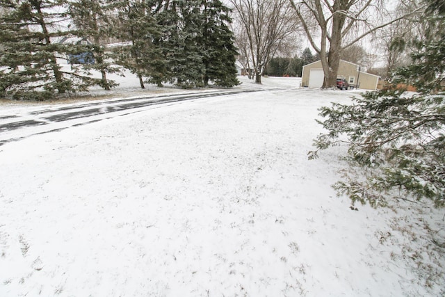 yard layered in snow featuring a detached garage