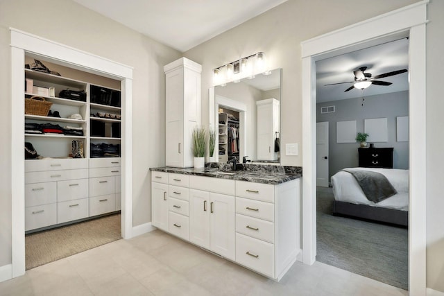 3028 Pinewood Rd SE, Rochester, MN 55904 - bathroom featuring a ceiling fan, vanity, baseboards, a spacious closet, and connected bathroom