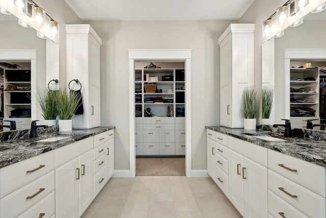 3028 Pinewood Rd SE, Rochester, MN 55904 - full bathroom with a walk in closet, two vanities, and baseboards