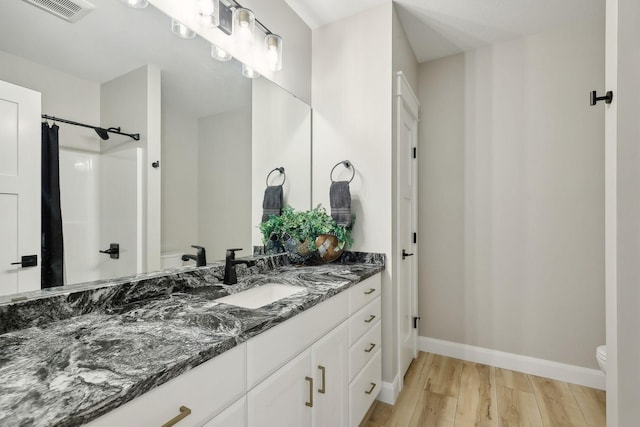 3028 Pinewood Rd SE, Rochester, MN 55904 - full bath with wood finished floors, toilet, curtained shower, baseboards, and vanity