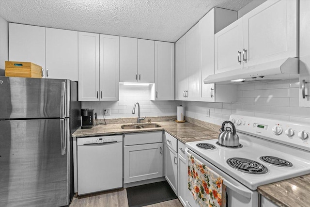 kitchen with white appliances, light hardwood / wood-style floors, white cabinetry, and sink