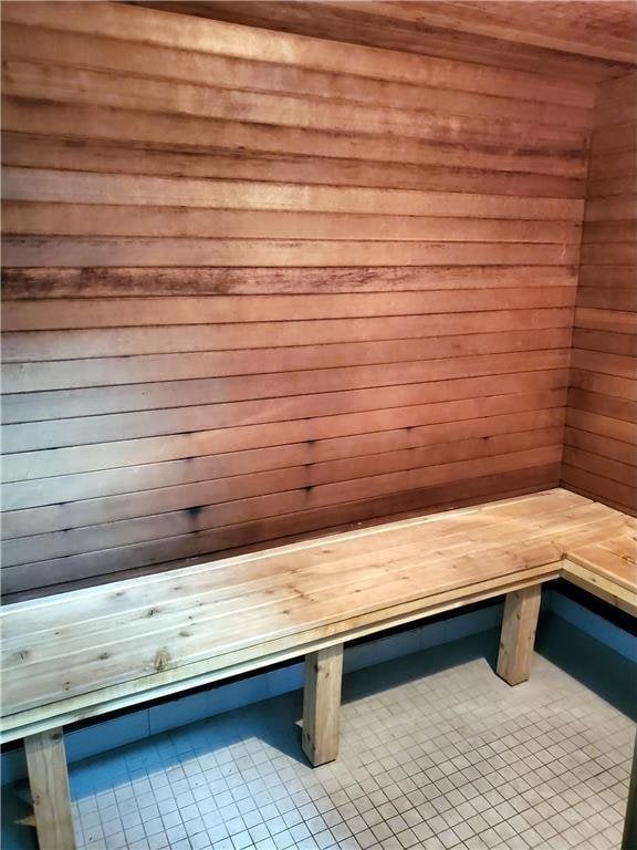 view of sauna / steam room featuring tile patterned flooring and wood walls