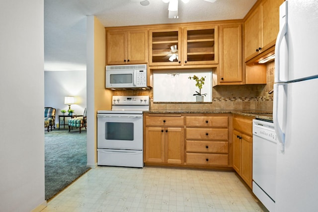 kitchen featuring ceiling fan, stone counters, backsplash, and white appliances