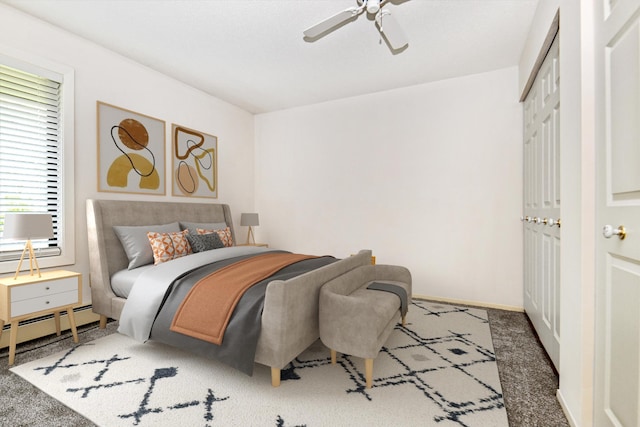 carpeted bedroom featuring ceiling fan, a closet, and baseboard heating