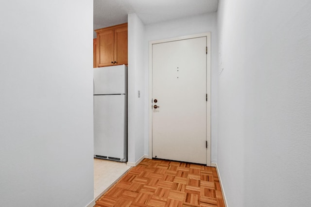 doorway featuring a textured ceiling and light parquet floors