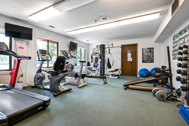 exercise room with a textured ceiling