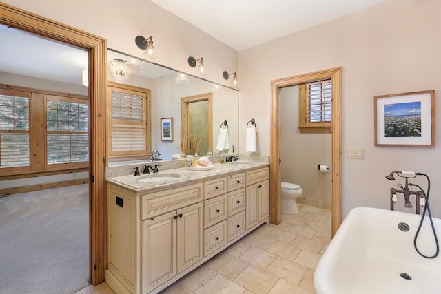 bathroom with a bathtub, toilet, and vanity