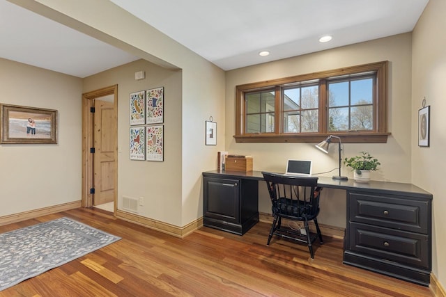 office with hardwood / wood-style floors and built in desk