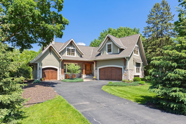 craftsman house with a front lawn and a garage