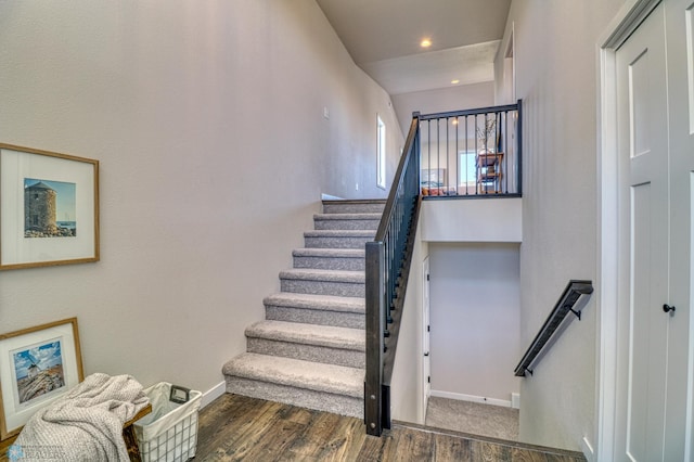 stairway featuring baseboards, wood finished floors, and recessed lighting