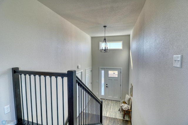 foyer entrance with hardwood / wood-style flooring and an inviting chandelier