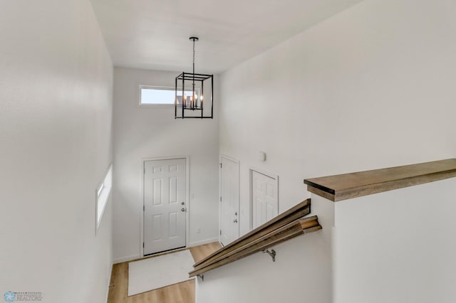 7043 Benji Ln, Fargo, ND 58047 - entryway featuring light wood-style floors, a towering ceiling, a chandelier, and baseboards