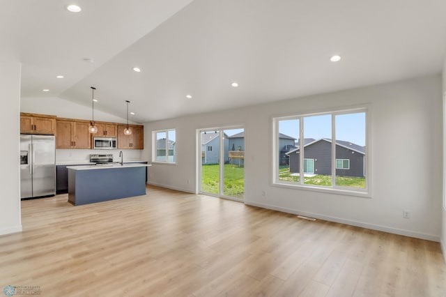 7043 Benji Ln, Fargo, ND 58047 - kitchen featuring stainless steel appliances, open floor plan, an island with sink, a sink, and vaulted ceiling