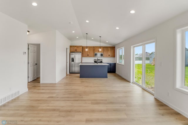 7043 Benji Ln, Fargo, ND 58047 - kitchen with stainless steel appliances, lofted ceiling, a center island, brown cabinets, and hanging light fixtures