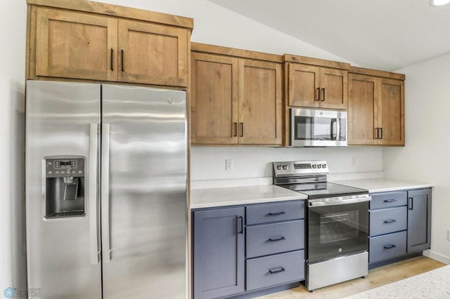 7043 Benji Ln, Fargo, ND 58047 - kitchen with appliances with stainless steel finishes, vaulted ceiling, light countertops, and brown cabinetry