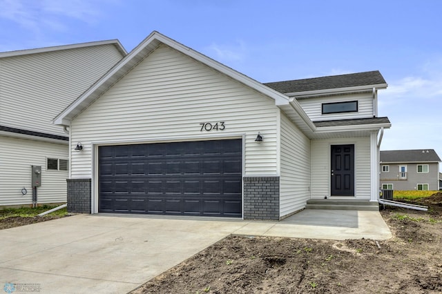 7043 Benji Ln, Fargo, ND 58047 - view of front of home with a garage, driveway, and brick siding