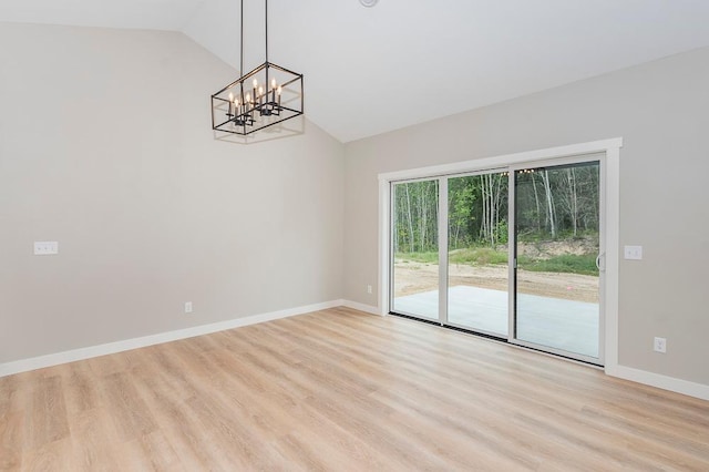 interior space with light hardwood / wood-style floors, lofted ceiling, and a notable chandelier