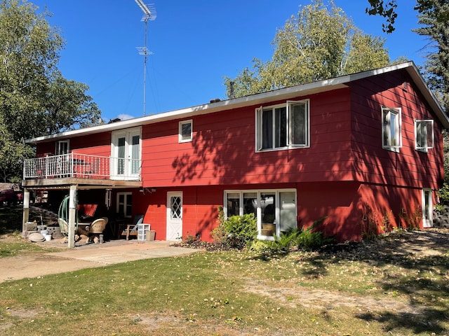 rear view of property featuring a patio area and a lawn