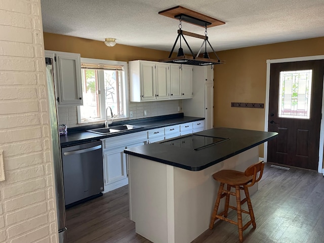 kitchen with sink, dishwasher, a center island, white cabinetry, and dark hardwood / wood-style floors