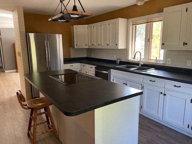 kitchen featuring sink, a kitchen island, white cabinetry, and light hardwood / wood-style floors