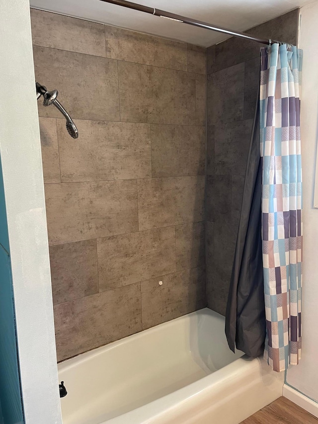 bathroom with shower / bath combination with curtain and hardwood / wood-style flooring