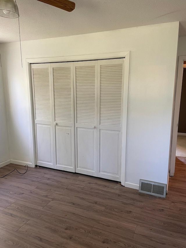 unfurnished bedroom with a closet and dark hardwood / wood-style flooring