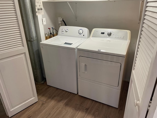 clothes washing area with washer and clothes dryer and light hardwood / wood-style floors