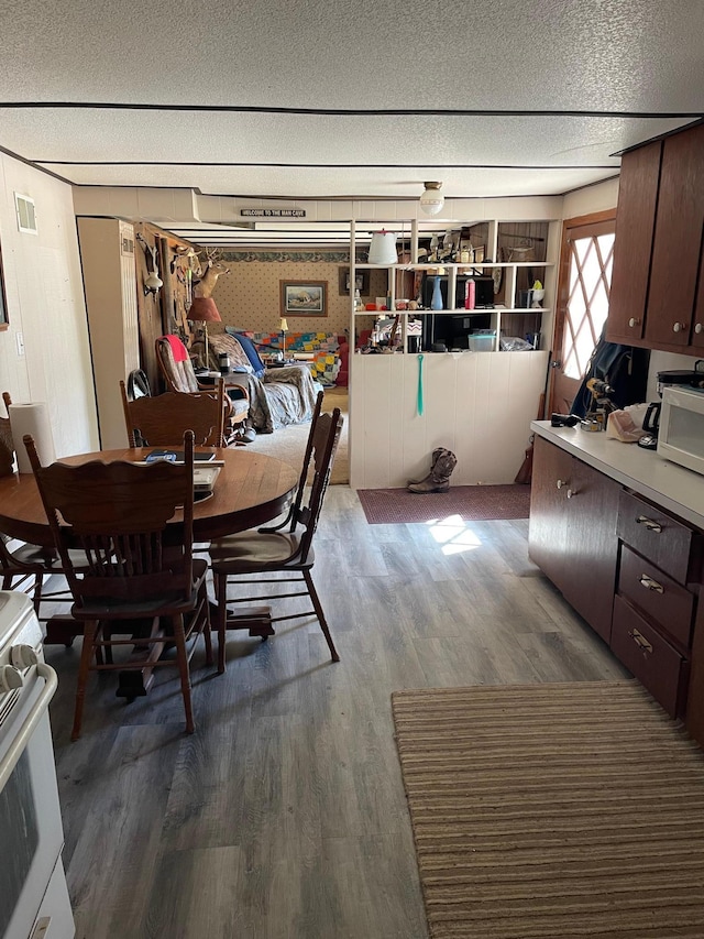 dining space with hardwood / wood-style floors and a textured ceiling