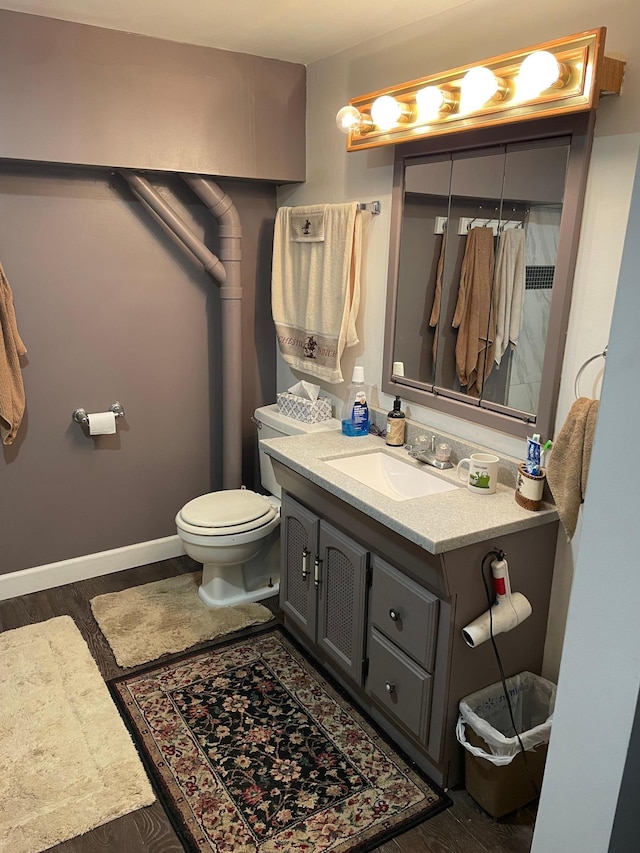 bathroom with vanity, toilet, and hardwood / wood-style floors