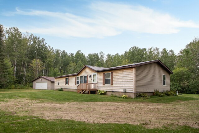 view of front of house with an outbuilding, a front yard, and a garage