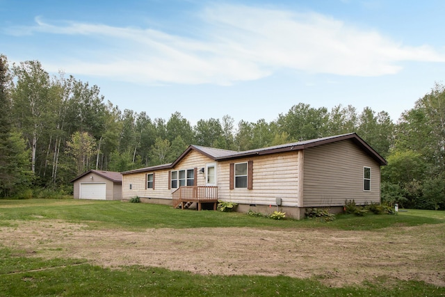 rear view of property with a yard, a detached garage, crawl space, an outdoor structure, and driveway