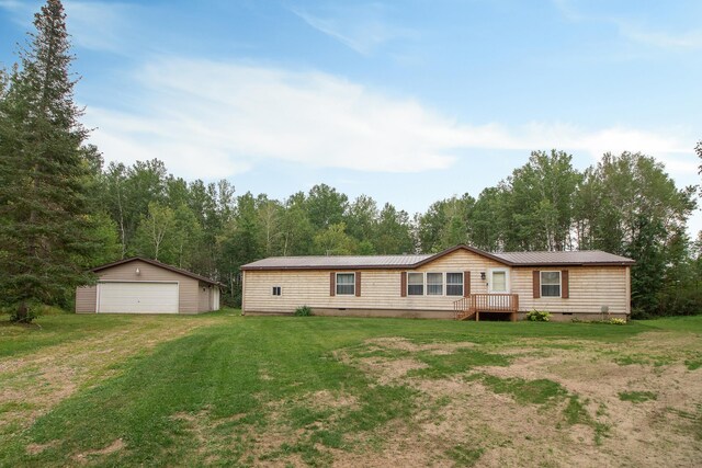 manufactured / mobile home with an outdoor structure, a garage, and a front yard