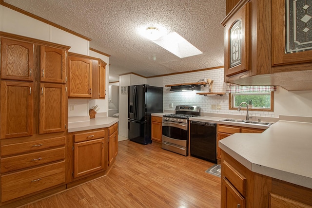 kitchen featuring ornamental molding, brown cabinetry, a sink, and black appliances