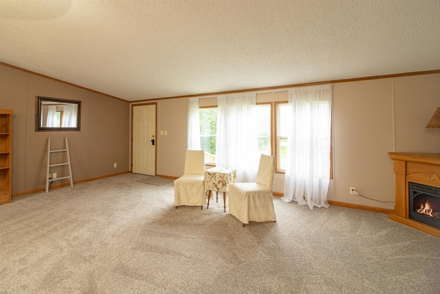 unfurnished room with carpet floors, crown molding, a glass covered fireplace, vaulted ceiling, and a textured ceiling