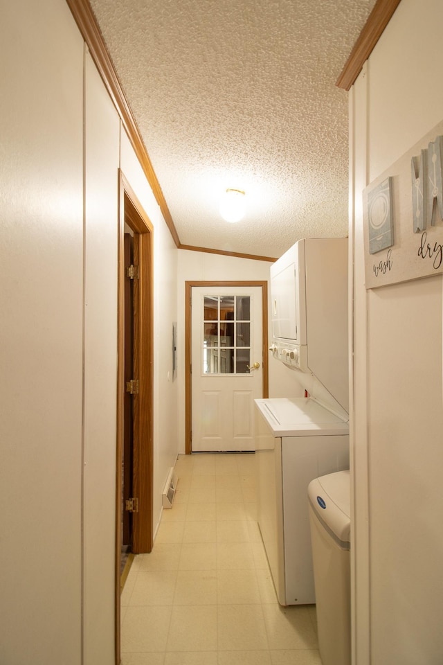 laundry room featuring laundry area, stacked washing maching and dryer, crown molding, and a textured ceiling