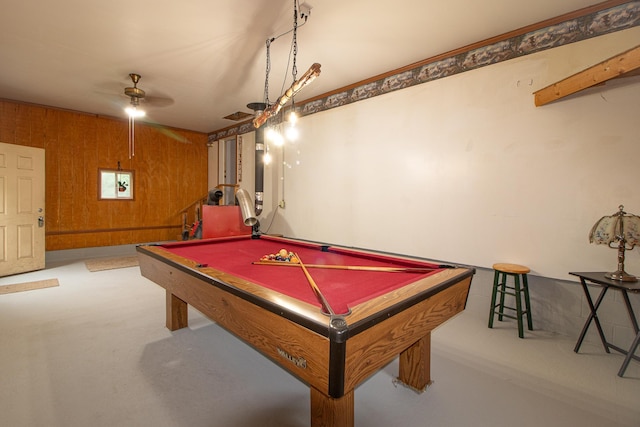 recreation room featuring wooden walls, finished concrete floors, a ceiling fan, and pool table