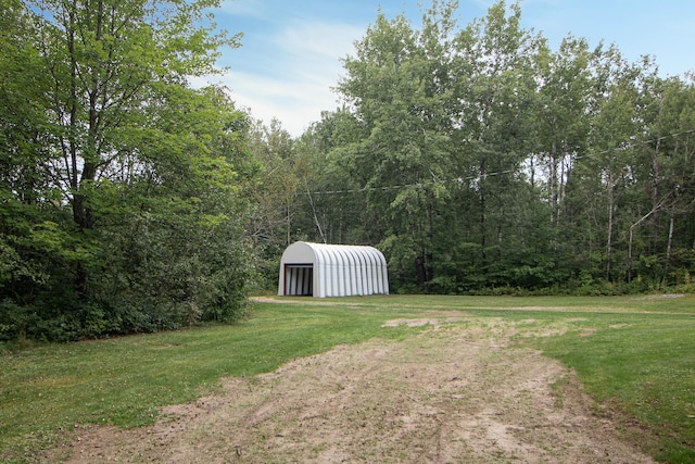 view of yard featuring an outbuilding, a pole building, and a detached carport