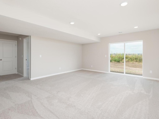 spare room featuring recessed lighting, light carpet, and baseboards