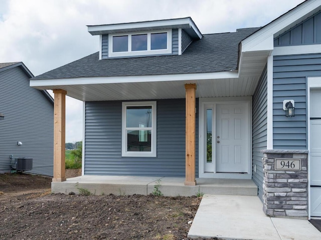 doorway to property with covered porch and central air condition unit