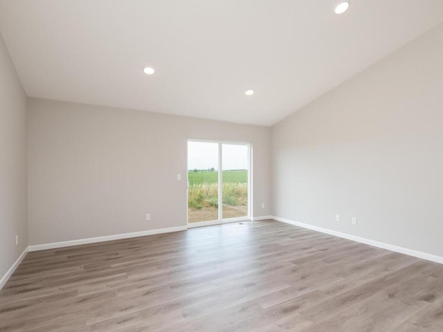 empty room with light wood-style floors, recessed lighting, and baseboards