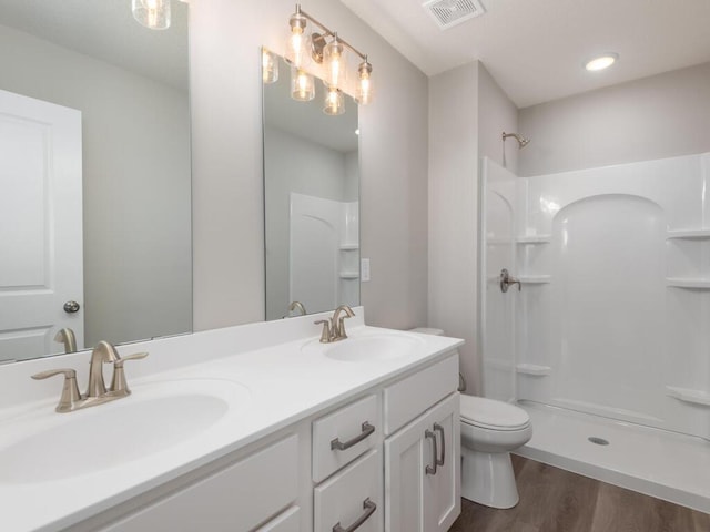 bathroom with visible vents, a sink, toilet, and wood finished floors