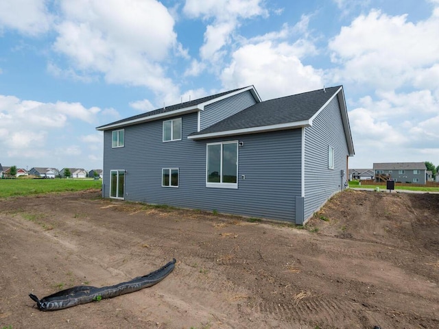 view of side of home with a shingled roof